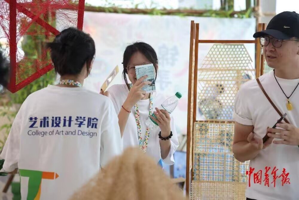 参观者在了解沐川草龙草扎技艺